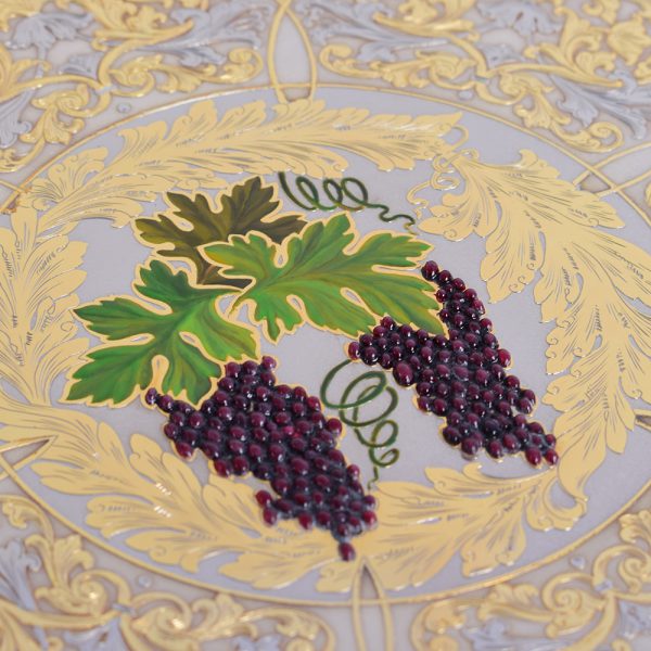 Artistic drawing of grapes on a golden dish