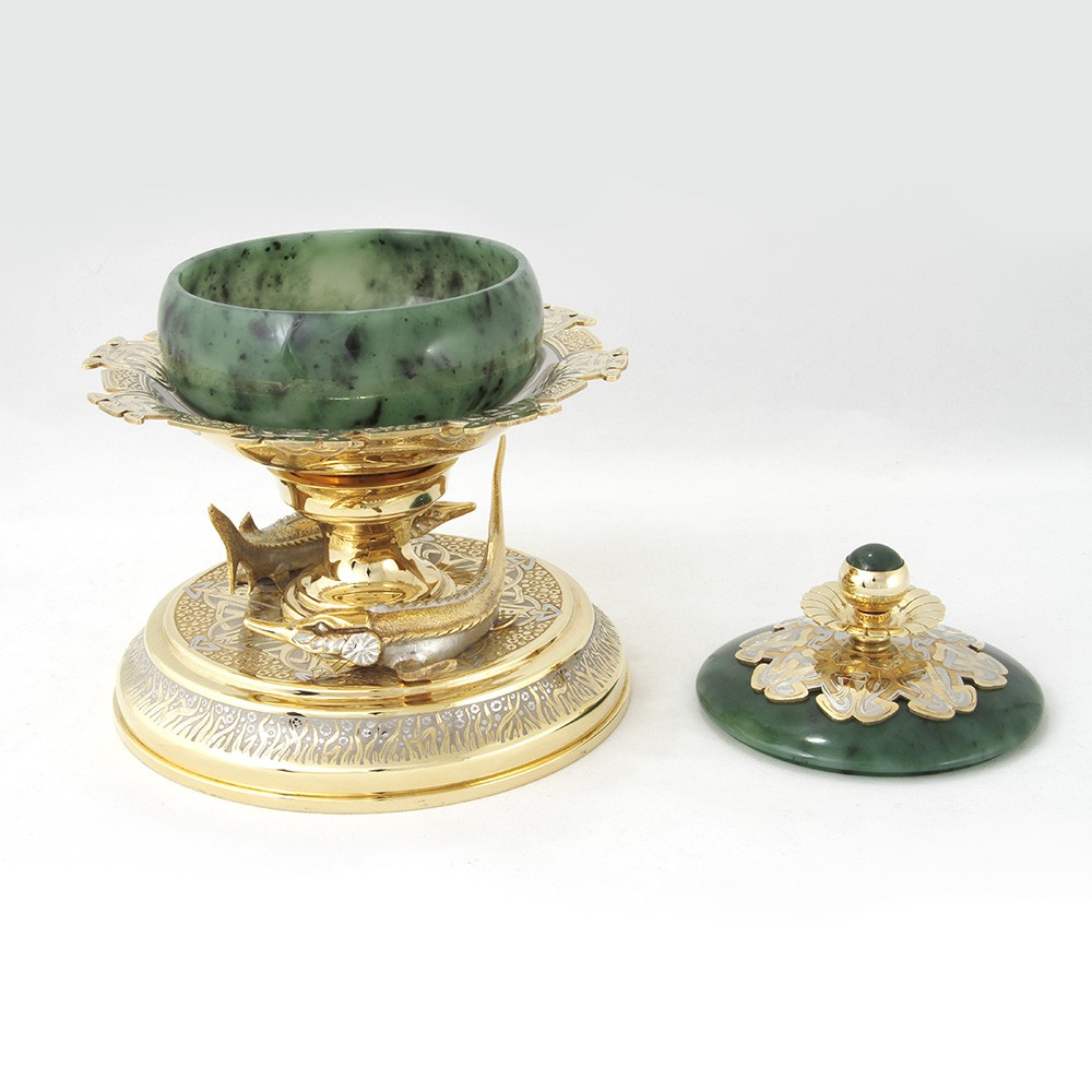 Jade bowl for red and black caviar on a gold platform surrounded by sturgeons