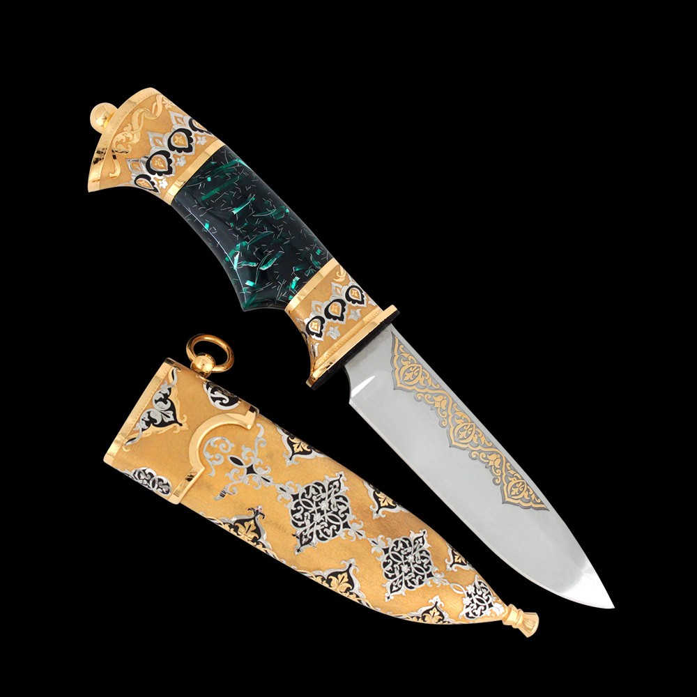 Stylish Arabic knife decorated with metal carvings, gold and a green hilt.