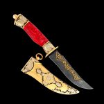 سكين عربي فاخر مع حافة حمراء وغمد أنيق مزين بزخارف تقليدية.
