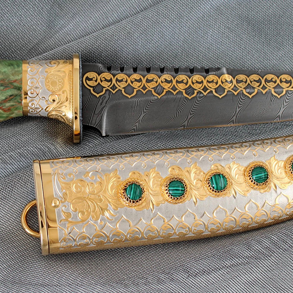 The scabbard is made of metal, its surface is decorated with relief patterns. Such a pattern is formed by manual cutting of metal with a cutter.