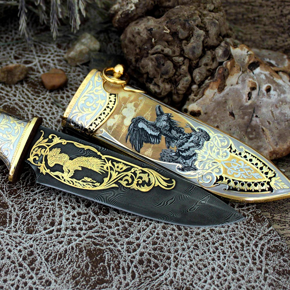 The blade and scabbard of a luxurious knife decorated with a golden image of an eagle
