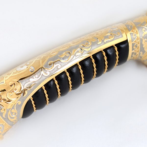 Luxurious golden hilt of a knife with a leather insert covered in gold wire.