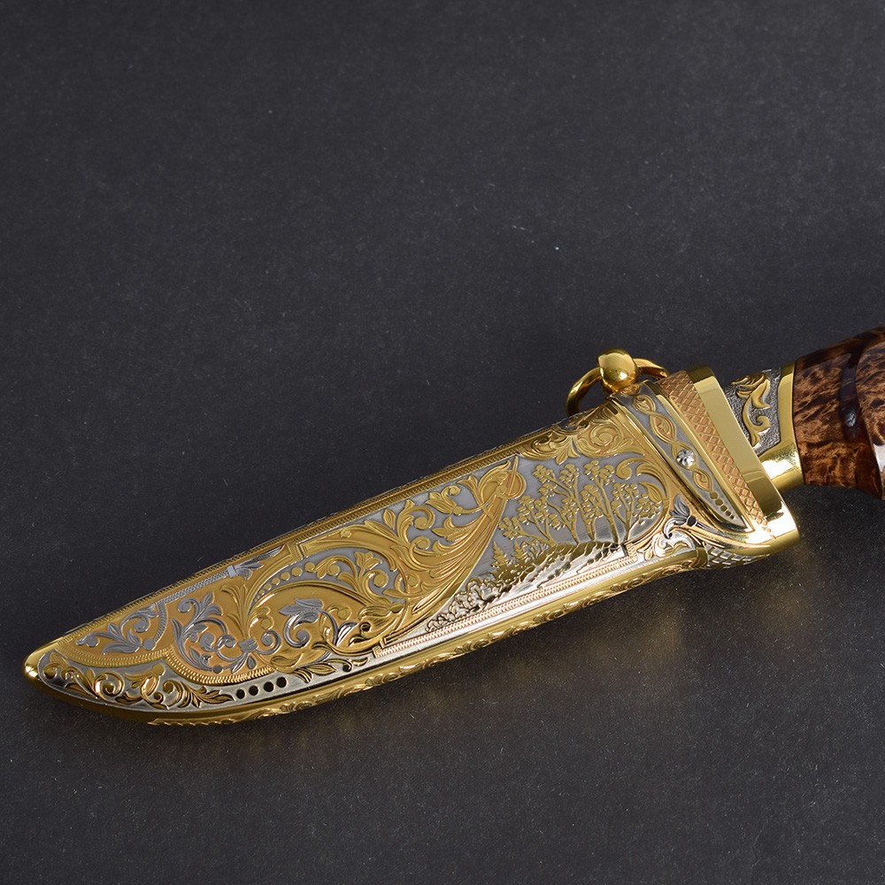 Golden scabbard decorated with floral ornaments in the style of Zlatoust metal engraving.