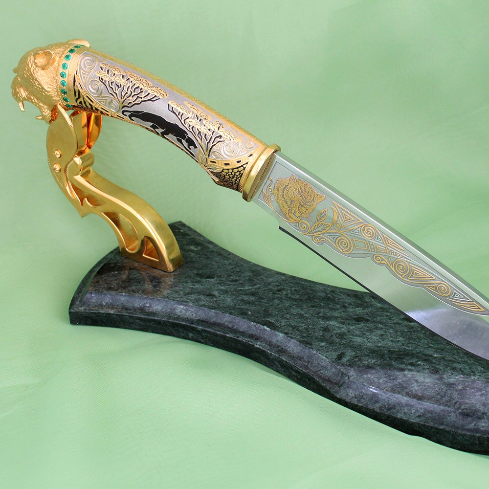 Luxurious handmade knife made of high alloy steel decorated with gold and black panther pattern. The knife supplies a stand made of natural stone.