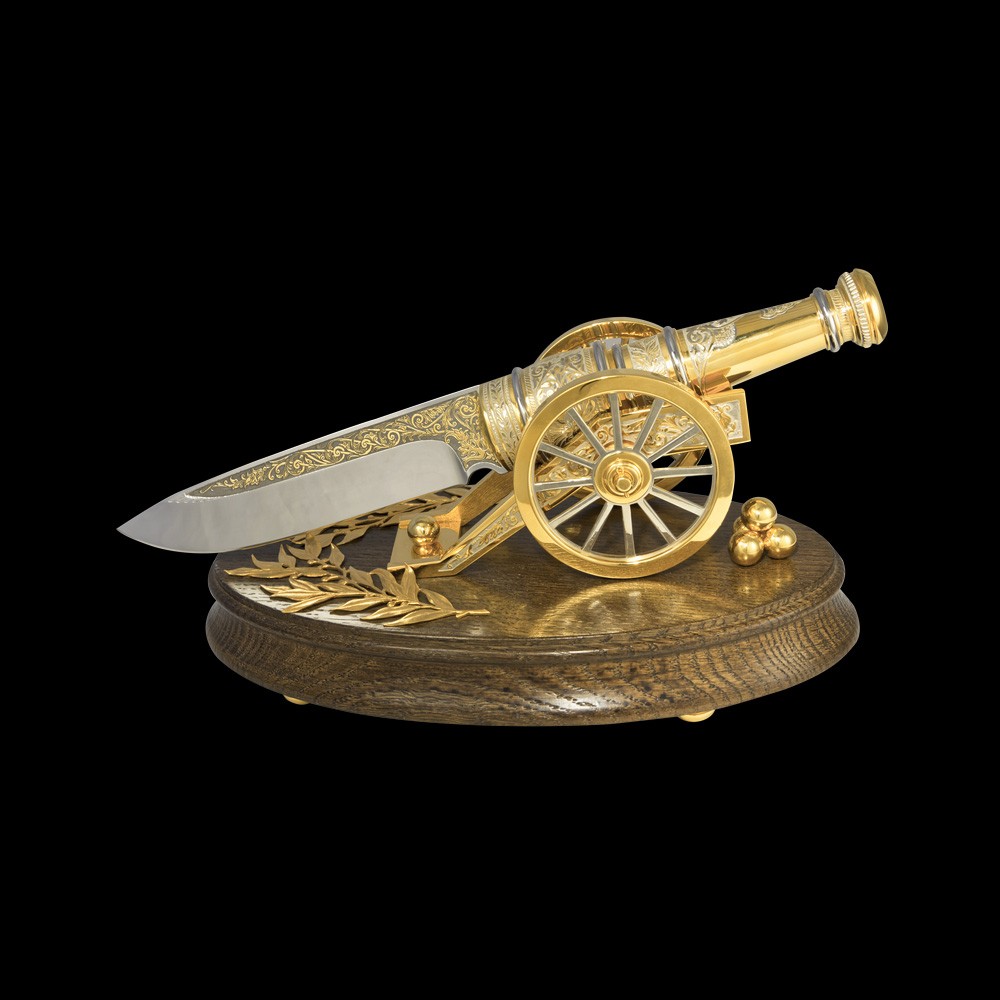 Knife gun - a luxurious exposition of a knife in the form of a golden gun on a wooden base. Exclusive corporate gift.
