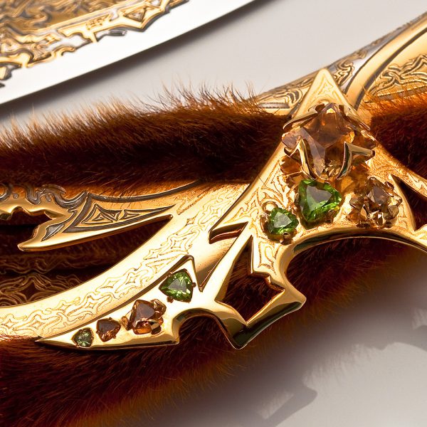 This item is a work of decorative art made in the traditional technique of Zlatoust metal engraving, using galvanic methods of etching, gilding, nickel plating. The dagger also reflected the original combination of jewelry stones and seal fur.