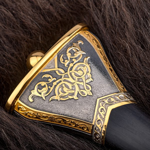 The head of the dagger decorated with hand-carved patterns coated with gold and rhodium