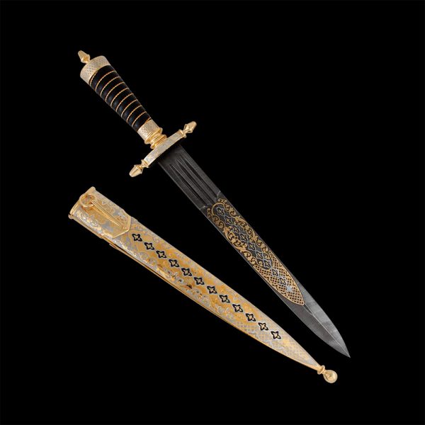 A stylish dagger similar to a small sword. A black leather handle is tied with twisted wire. The scabbard is decorated with an engraved pattern on a metal surface.