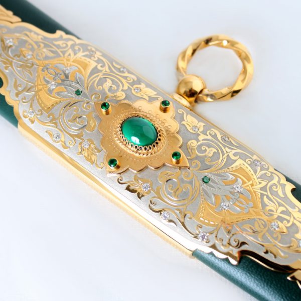 Green scabbard of arabic sword decorated with gold inlay with jewelry stones.