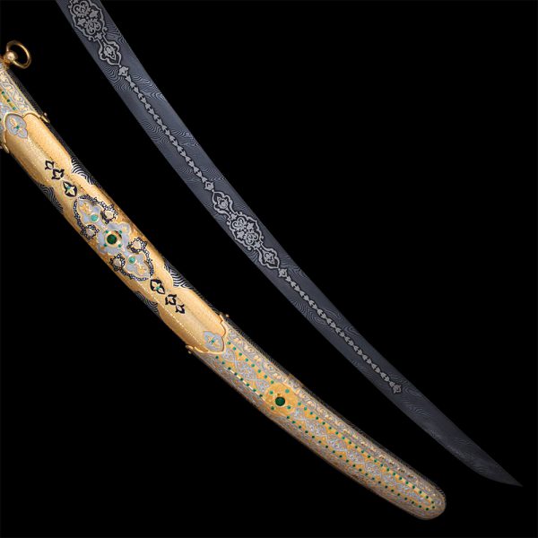 Gold scabbard of arabic sword decorated in oriental style with green stones and hand engraving