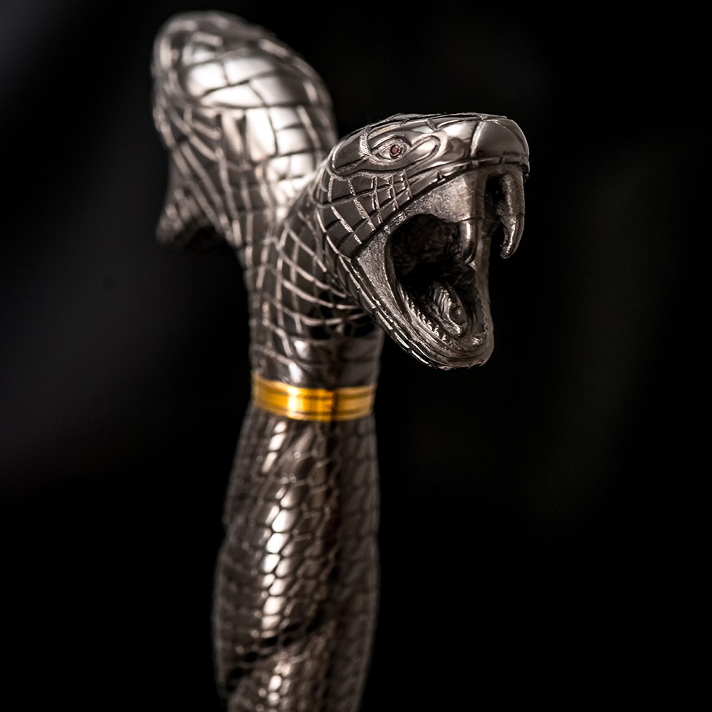 Metal handle in the shape of a snake with an open mouth.