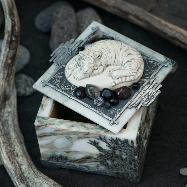 A square box of stone with a tiger on the lid.