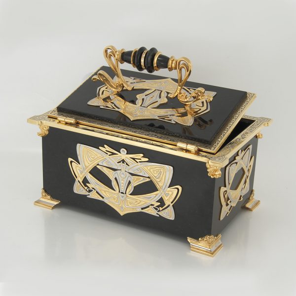 The medium-sized casket with a hinged lid is made by a stone turner from black natural stone. Each element of its decor is cast from a metal alloy.