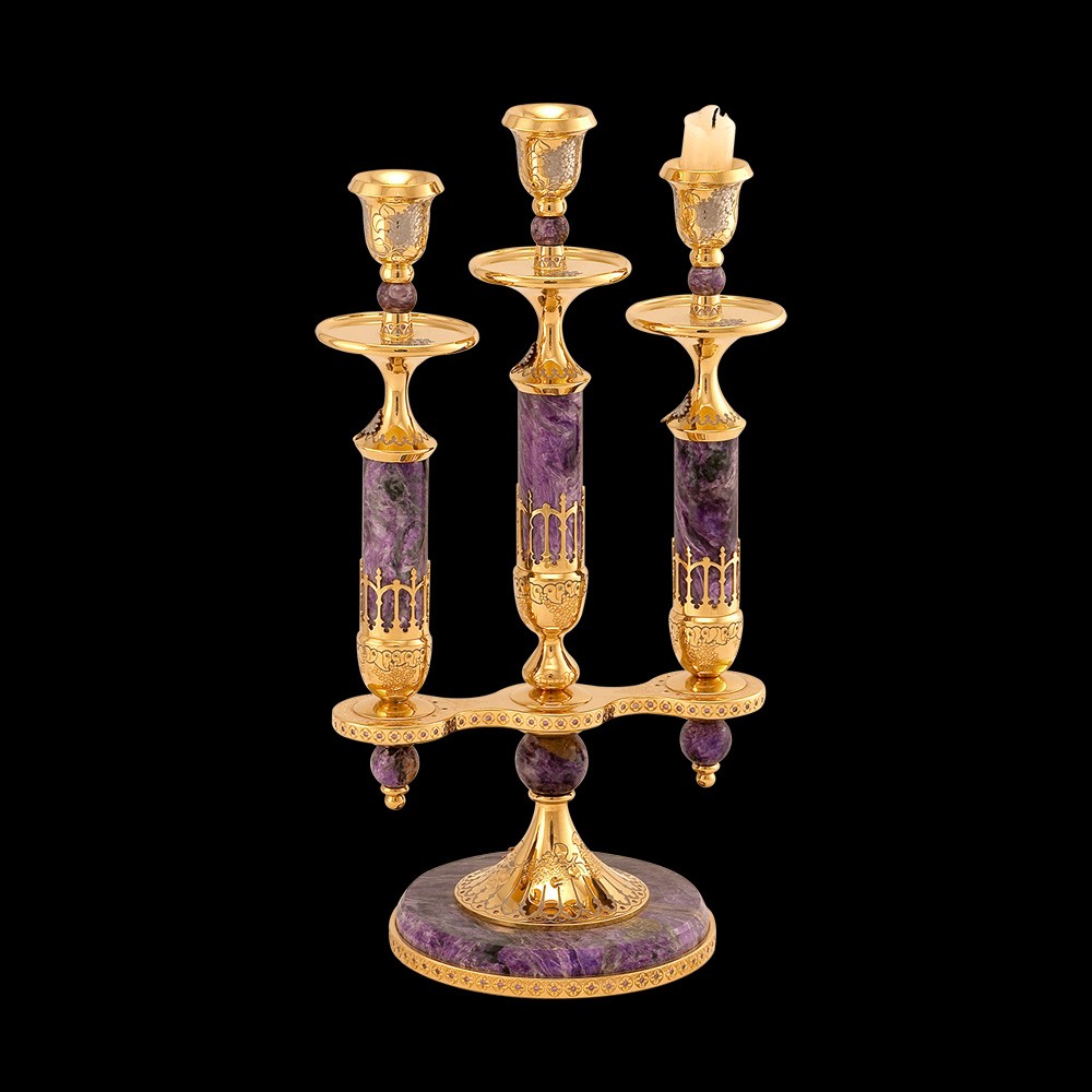 A candle holder made of charoite, decorated in the style of Zlatoust engraving on metal, will give the house a special charm and will testify to a good sense of taste and noble luxury.