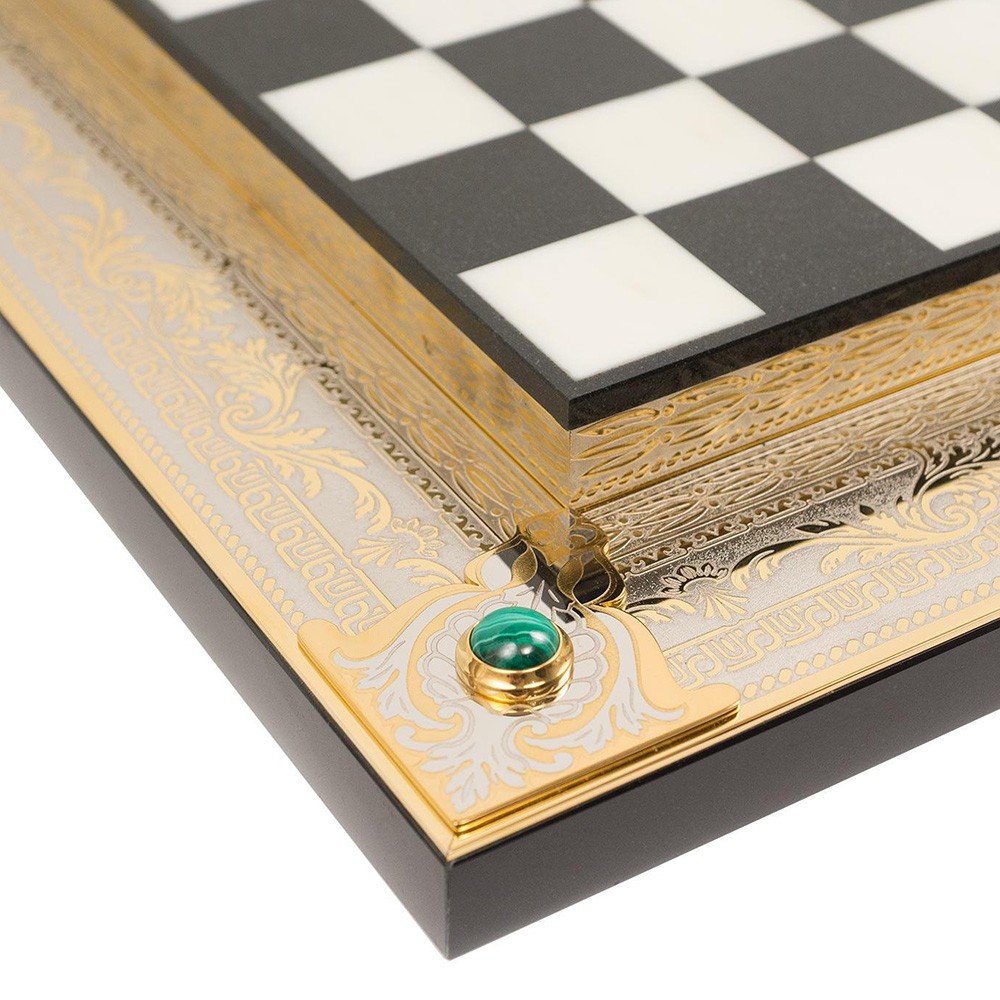 Two-level chessboard made of stone. The contour is decorated with gold plates with embossed engraving