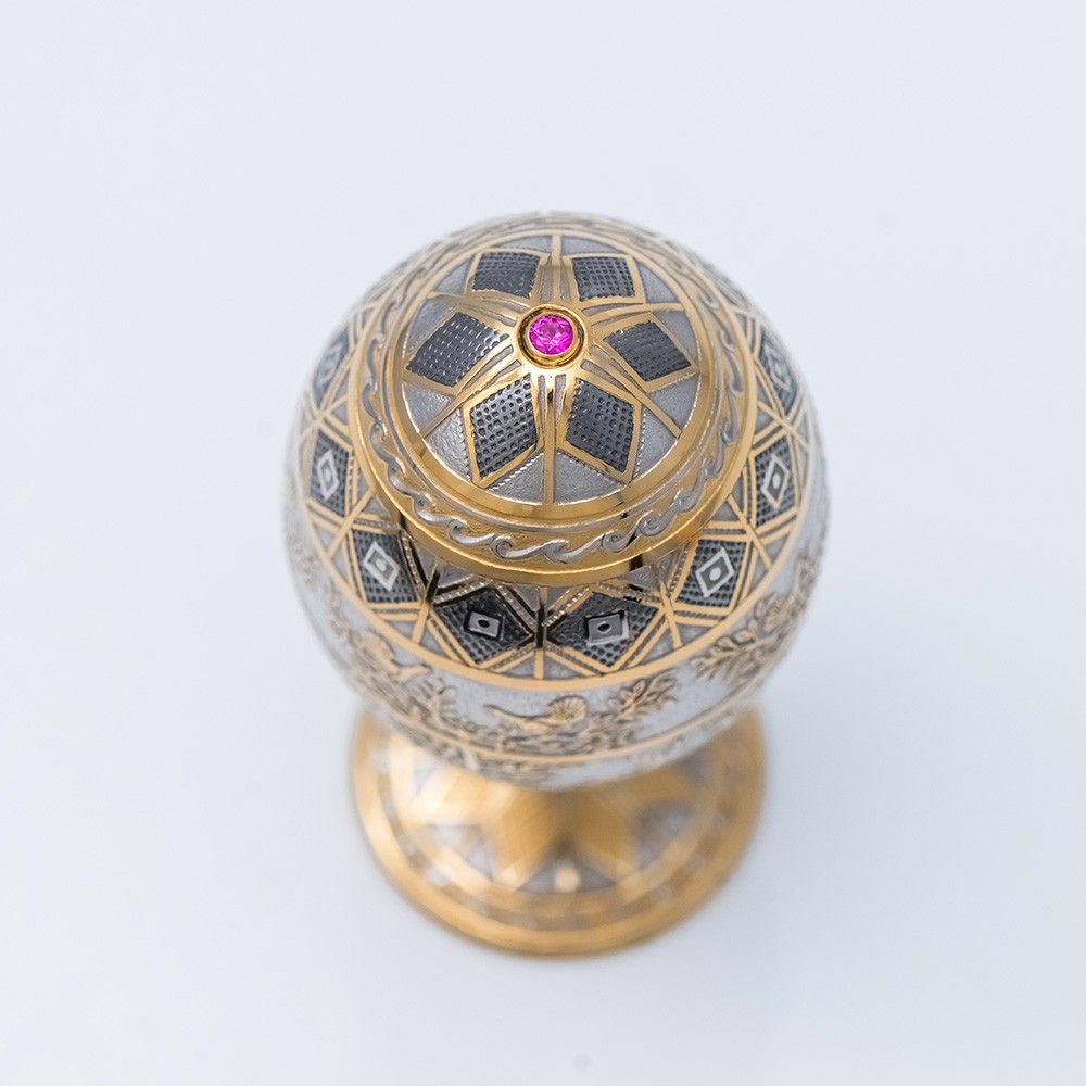 Jewelry egg made of metal covered with gold and ornament.
