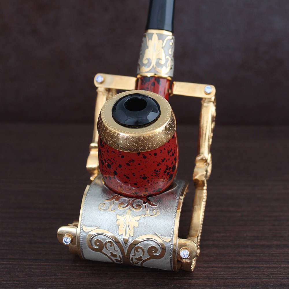 A volcanic glass smoking pipe on a gold stand.