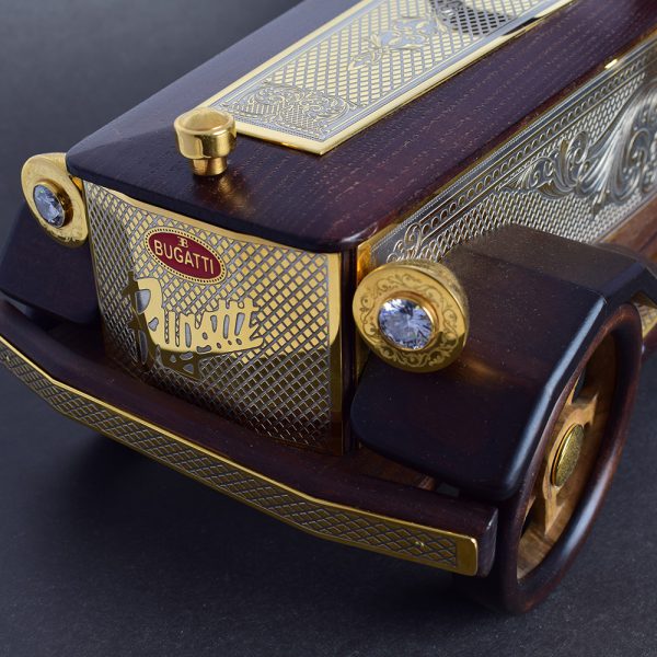 Jewelry model of a car brand Bugatti. In retro headlights inlaid with transparent crystals. The radiator grill is cut out under a microscope and coated with gold. A luxurious gift for a collector or business person