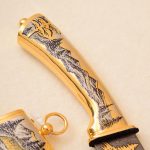 golden knife handle engraved with mountains