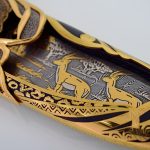 رسم فولاذ دمشق بزخارف ذهبية في فتحات الغمد