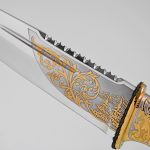 knife with teeth on the butt with a gold pattern