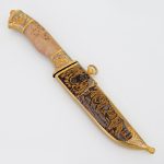 Knife with a wooden handle and a golden sheath with the image of a bear