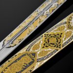 The scabbard and blade are decorated with an ornament with the addition of enamel and gold, as well as cubic zirconias of different colors.