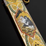 The scabbard is decorated with the image of a rider and an ornament with the addition of enamel and gold, as well as cubic zirconias of different colors.