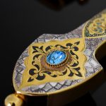 The handle of the dagger is decorated with a gold ornament with the addition of enamel and blue cubic zirkonia