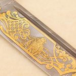 gold falcon engraving on damascus steel